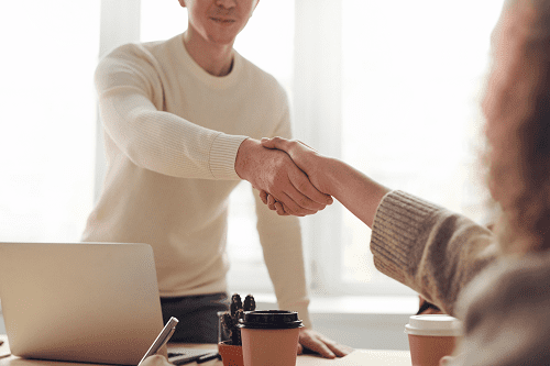 A person shaking hands in a business meeting.